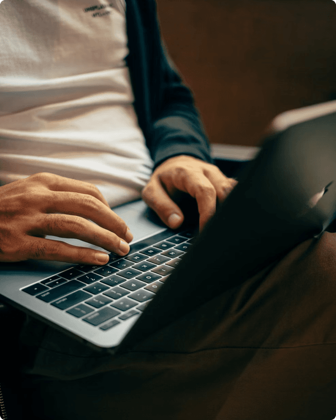 Close-up of a person typing on a laptop
